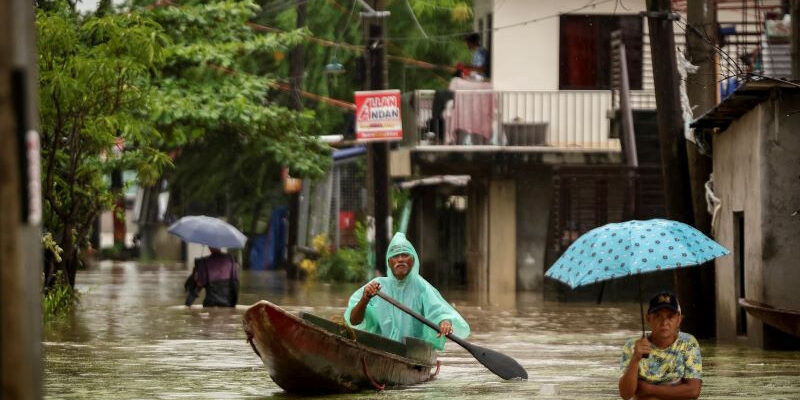 people wade through the floodwaters as it rains during tropical storm yagi locally known as enteng in apalit pampanga philippines september 5 2024 photo reuters